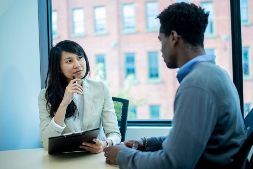 A media trainer listening actively to her trainee across a table