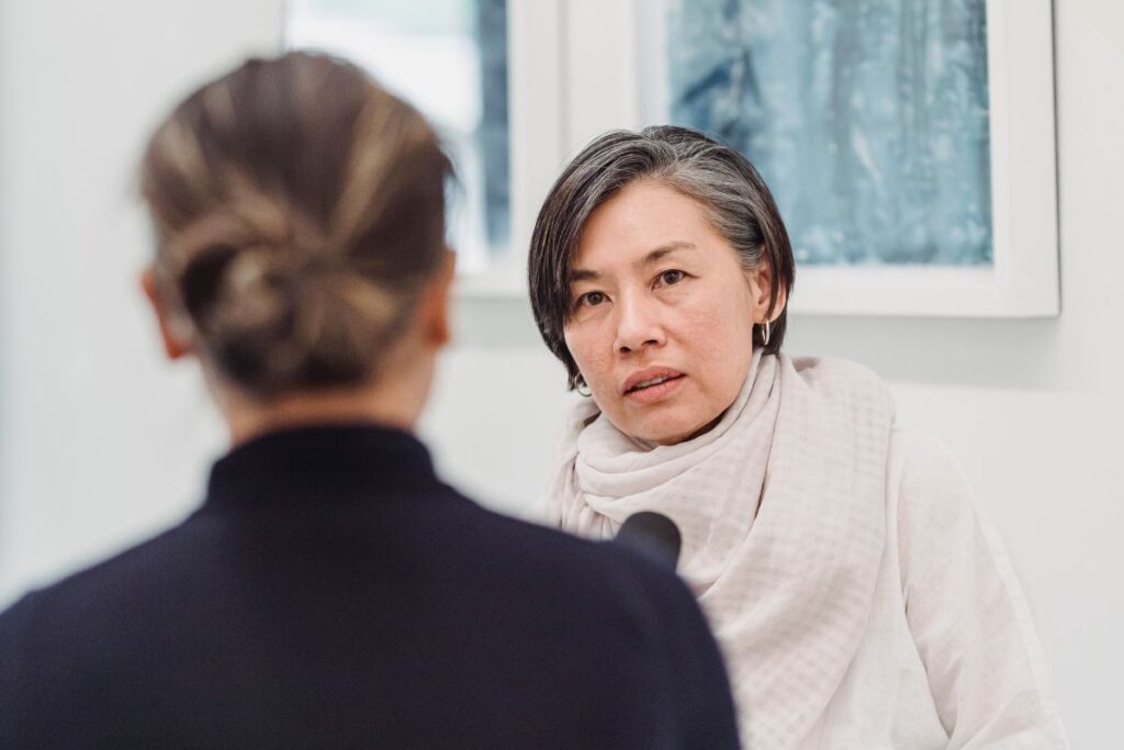 Nervous-looking woman being interviewed with a microphone in her face