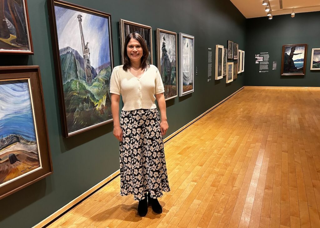 Jasmine Bradley poses in front of artworks at the Vancouver Art Gallery.