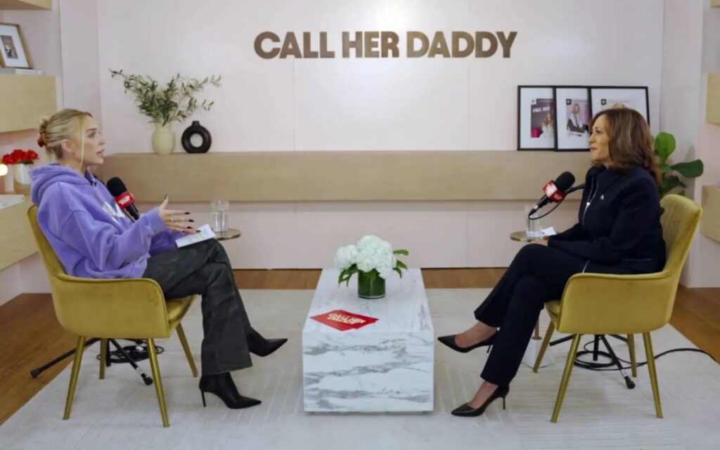 Alex Cooper and Kamala Harris seated across from each other on the set of the Call Her Daddy podcast